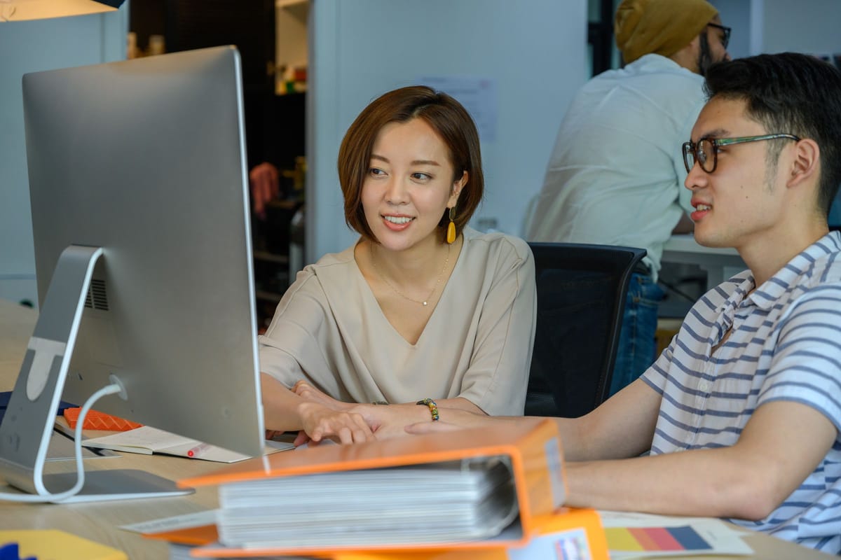 Two colleagues reviewing a participant dashboard together on one screen