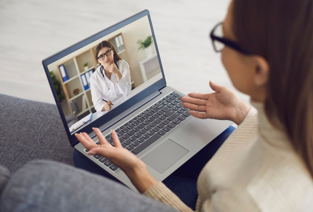 a virtual assistant taking notes while listening to her patient from her laptop